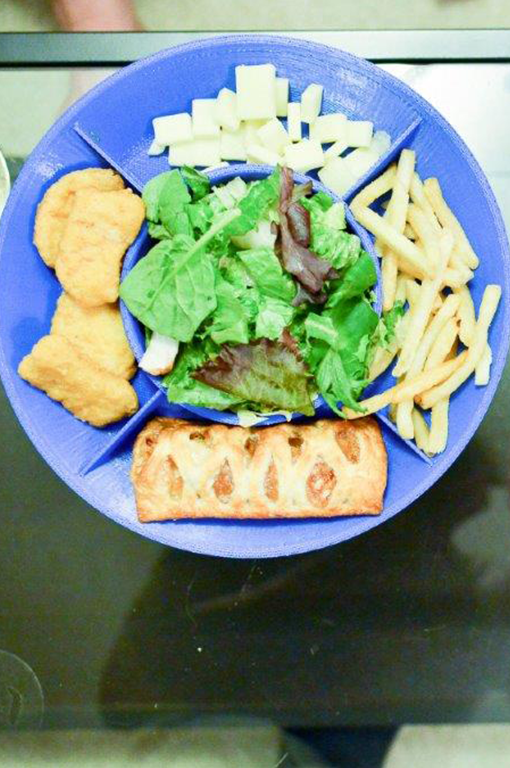 Colored bowl plate with mixed chips in the bowl portion and chicken nuggets and fries in the plate sections